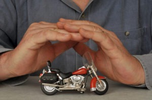 a man holding his hands over a toy motorcycle