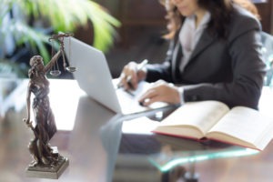 female lawyer working next to the scales of justice