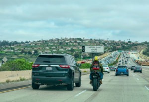 motorcyclist splitting lane on california road